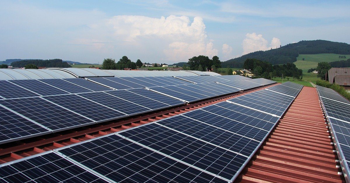 Fotovoltaik-Platten auf Dach vor hügeliger Landschaft