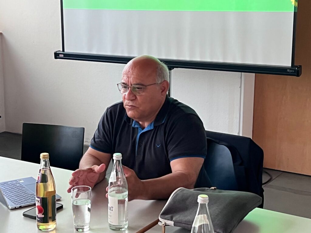 Cemal Bozoglu sitzt an Konferenztisch