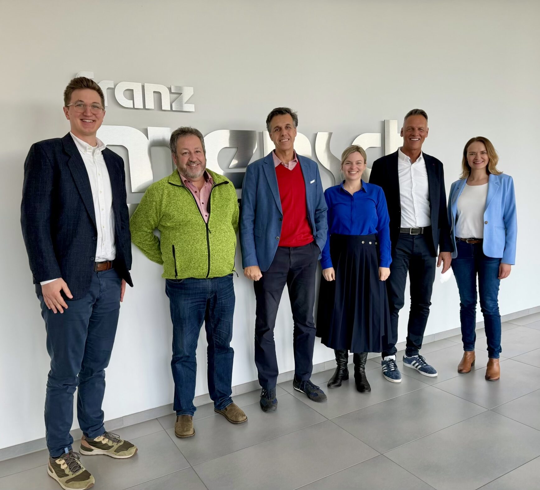 Gruppenfoto vor Franz Mensch Schriftzug an Wand